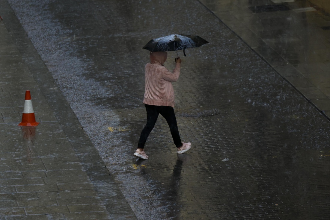 Persona se protege de la lluvia con paraguas. EFE/Biel Aliño