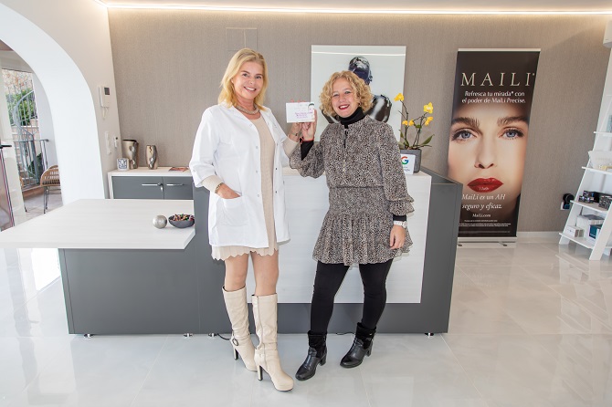 La directora de la Clínica Miramar entrega el premio del sorteo a la ganadora Aitana Casanova Castelló
